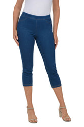 A front shot of a model wearing a pair of blue pull-on capri-length jeggings with an elastic waistband.