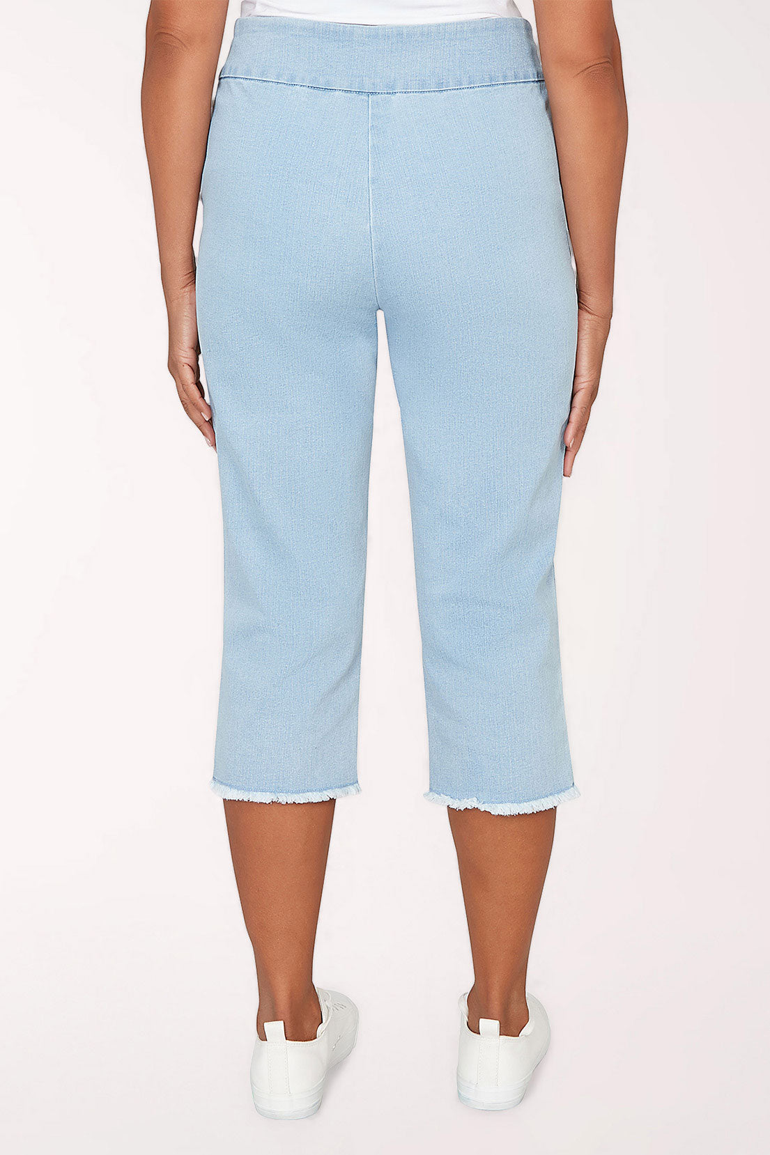 Woman wearing a light denim crop pant.
