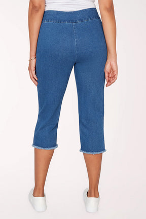 Person wearing blue denim capri pants on a white background