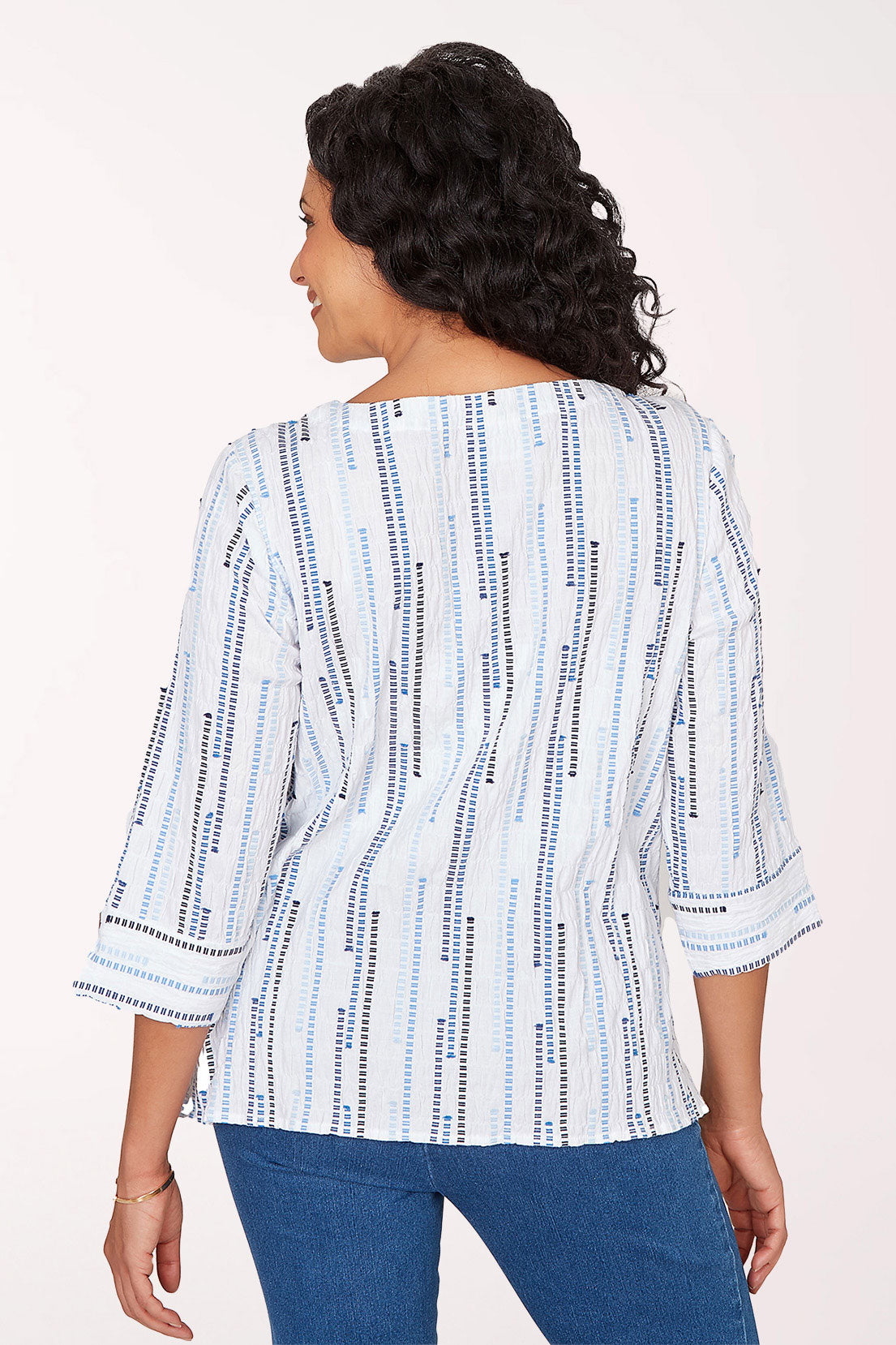 A woman wearing a blue multi 3/4 sleeve top.