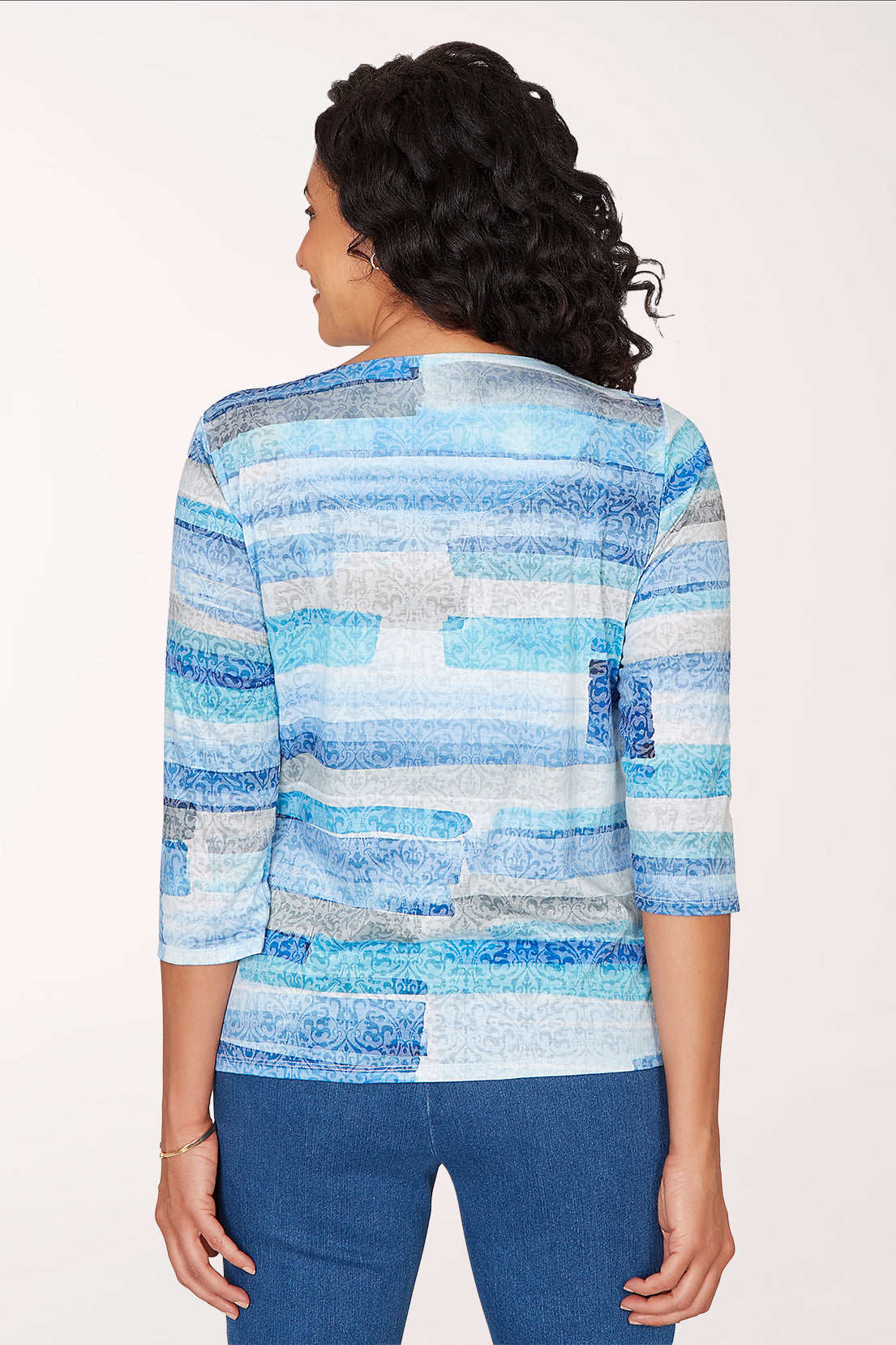 Woman wearing a 3/4 sleeve blue brushstroke top.