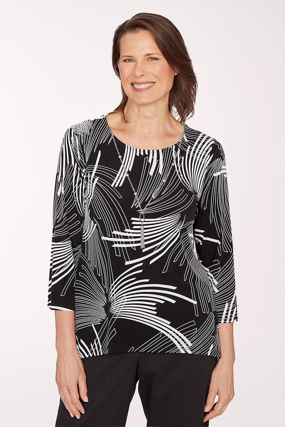 Woman wearing a black and white patterned top on a white background