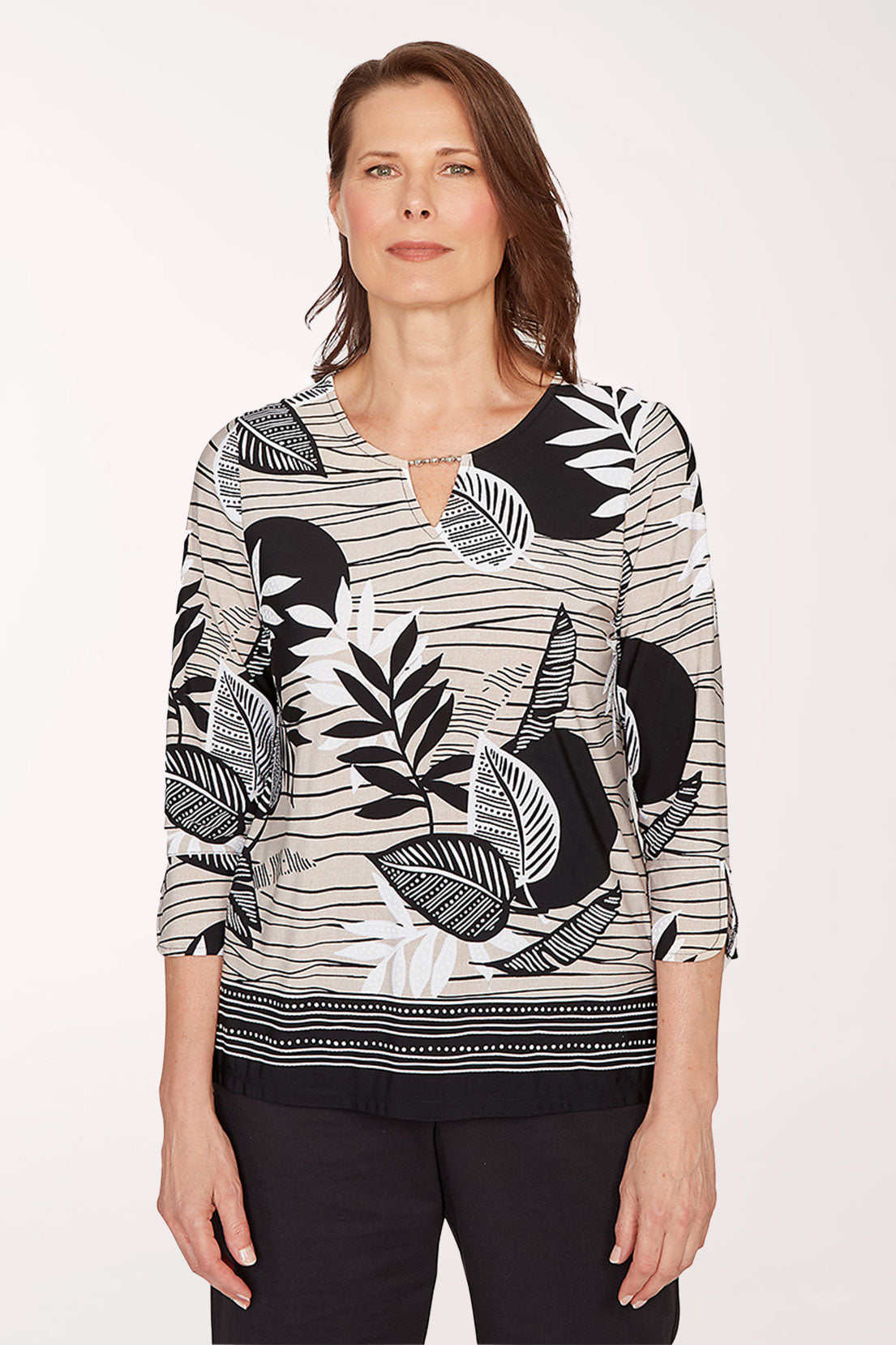 Woman wearing a black and white patterned blouse on a white background