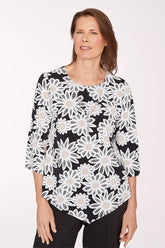 Woman wearing a black top with white floral lace pattern on a white background