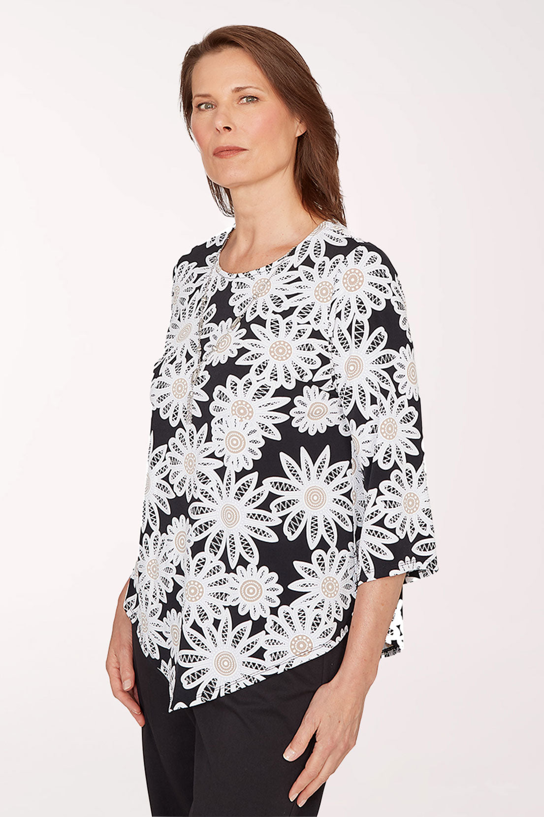 Woman wearing a black top with white floral lace pattern on a white background