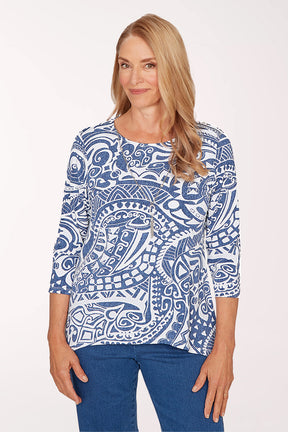 Woman wearing a blue and white patterned top on a white background