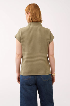 Woman wearing a olive green cap sleeve olive sweater with a mockneck