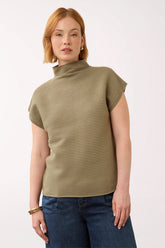 Woman wearing a olive green cap sleeve olive sweater with a mockneck