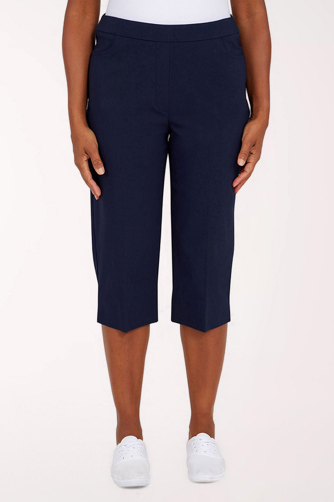 Navy blue capri pants worn by a person on a white background