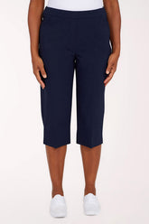 Navy blue capri pants worn by a person on a white background