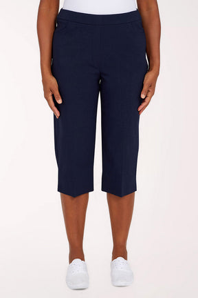 Navy blue capri pants worn by a person on a white background