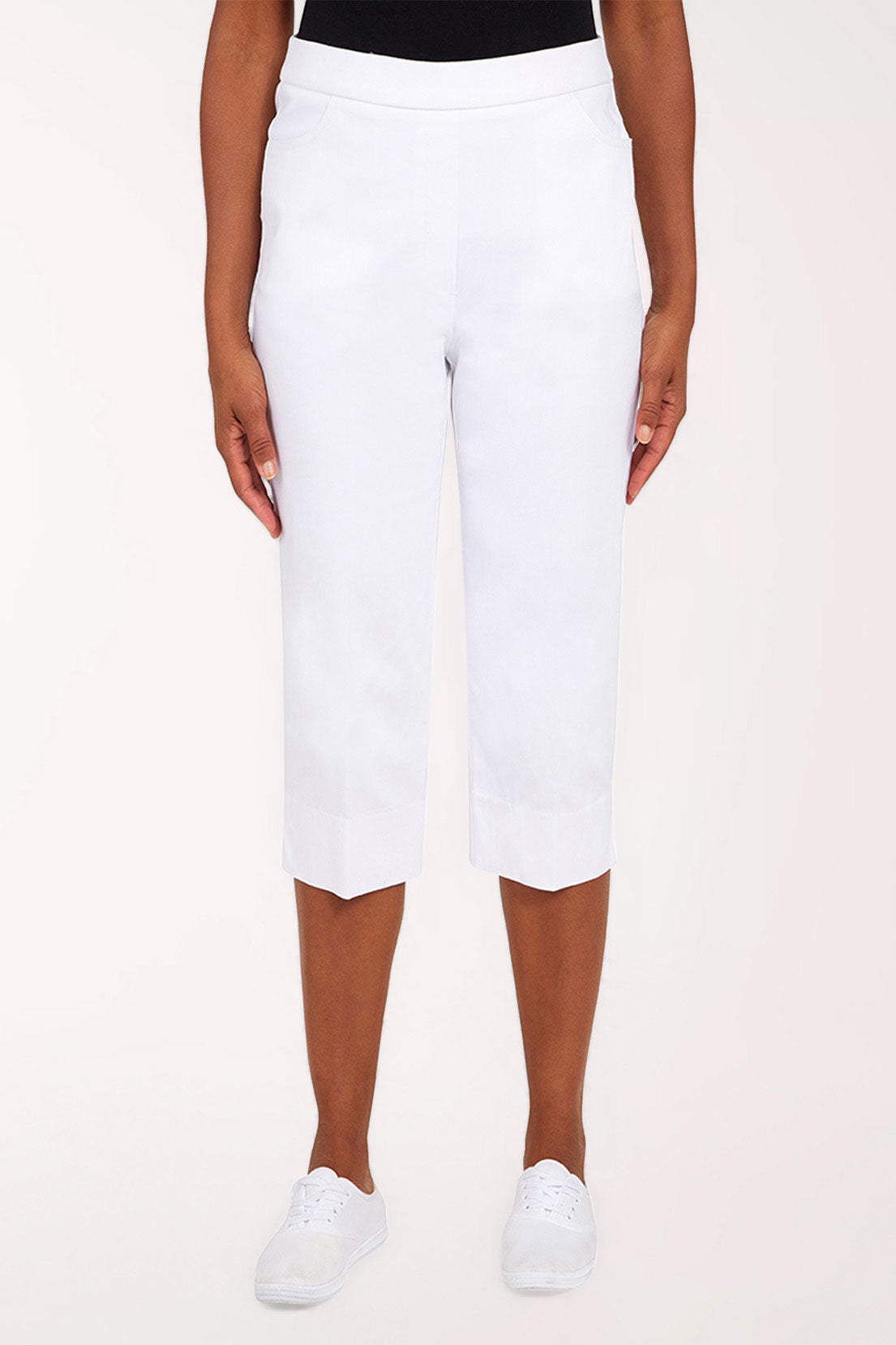 White capri pants worn by a person on a white background
