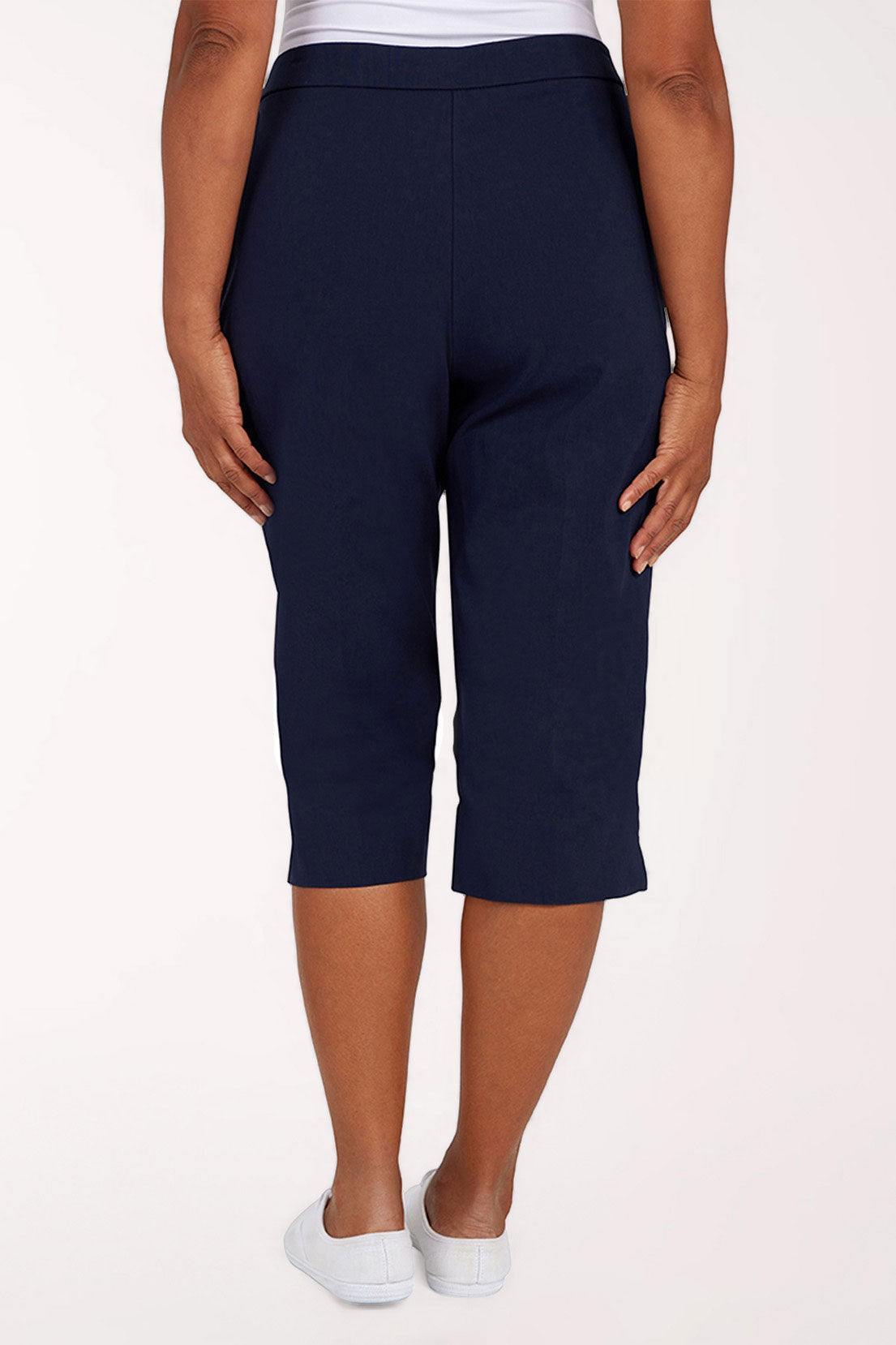 Navy blue capri pants worn by a person on a white background