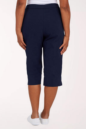 Navy blue capri pants worn by a person on a white background