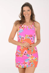 Woman wearing a colorful floral dress on a white background.