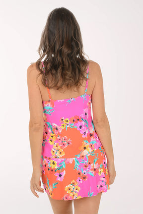 Woman wearing a colorful floral dress on a white background. Back shot.