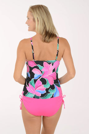 Woman wearing a colorful floral swimsuit on a white background. Back shot.