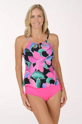 Woman wearing a colorful floral swimsuit with pink bottom on a white background.