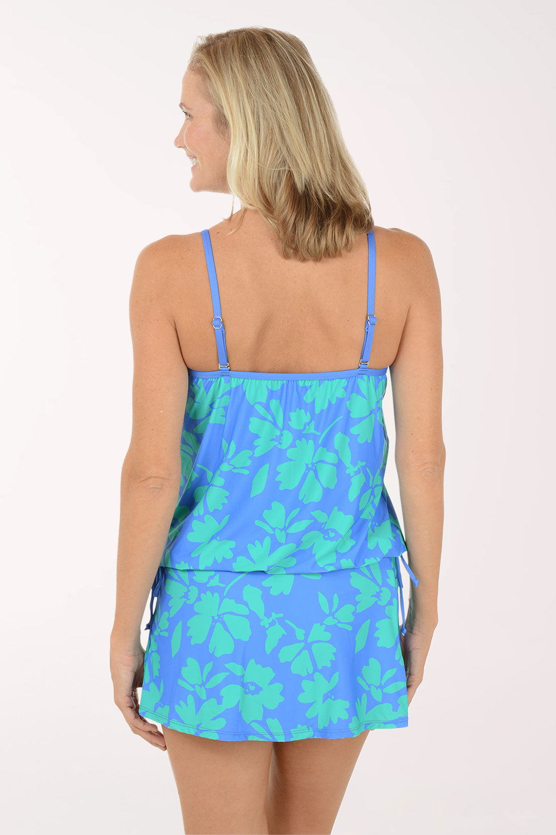 Woman wearing a blue floral dress on a white background. Back shot.