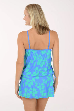 Woman wearing a blue floral dress on a white background. Back shot.