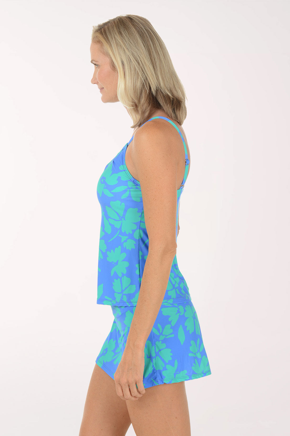 Woman wearing a blue floral dress on a white background. Side shot.