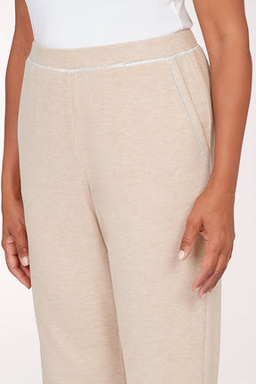 Beige pants worn by a person on a white background