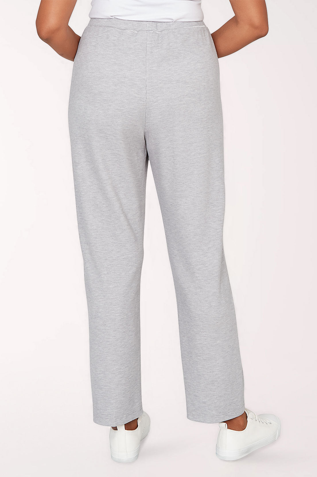 Gray sweatpants worn by a person on a light pink background