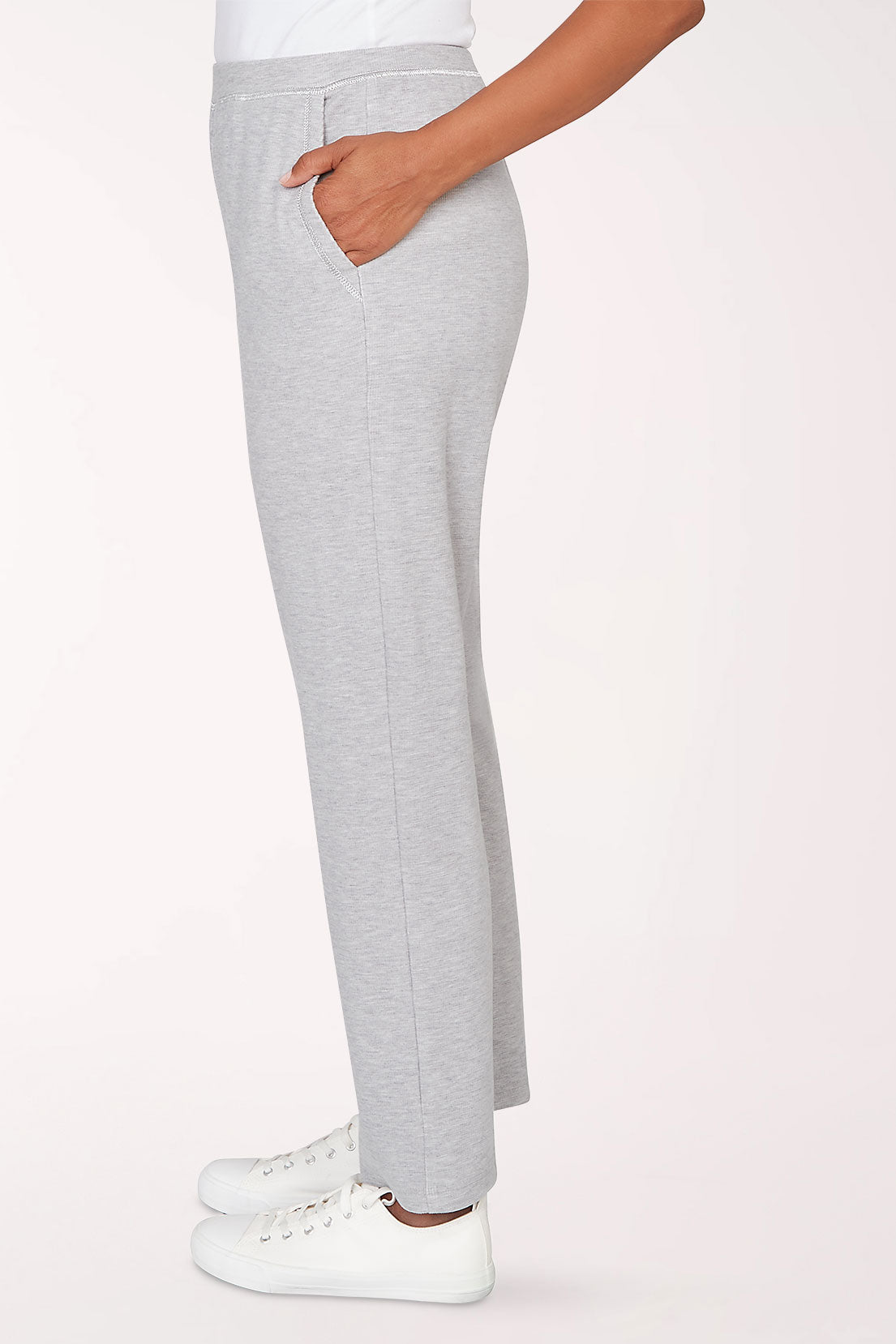 Gray sweatpants worn by a person on a light pink background
