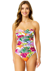 Woman wearing a colorful tropical print strapless swimsuit on a white background