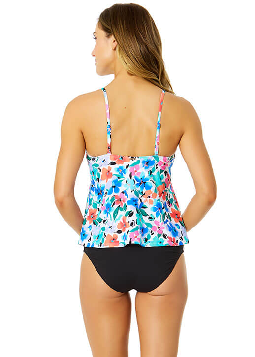 Woman wearing a floral tankini top and black bottoms on a white background