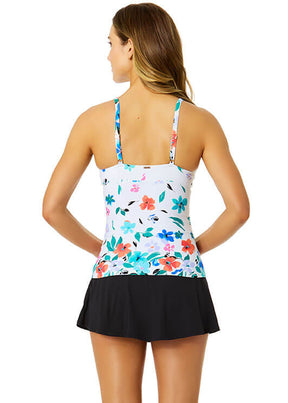 Woman wearing a floral tankini top and black skirt on a white background