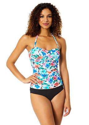 Woman wearing a floral tankini top and black bottoms on a white background