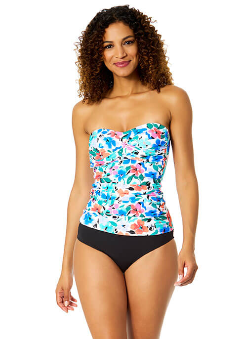 Woman wearing a floral strapless top and black high-waisted bikini bottom on a white background