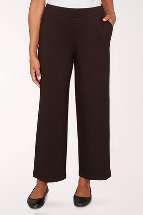 Black pants worn by a person on a white background