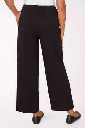 Black pants worn by a person on a white background