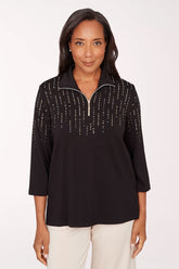 Woman wearing a black top with decorative trim on a white background