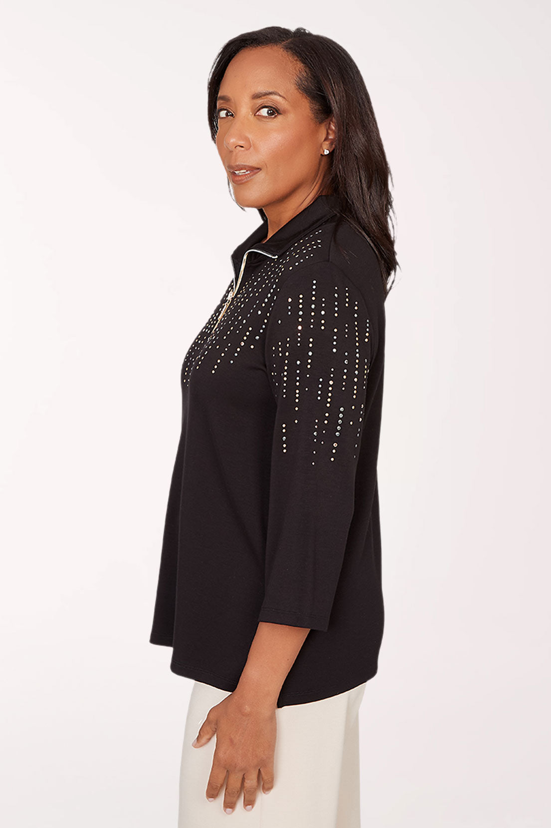 Woman wearing a black top with decorative trim on a white background