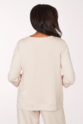 Woman wearing a white blouse with floral embellishments on a white background