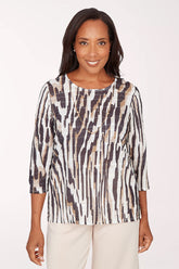 Woman wearing a patterned blouse with a plain background