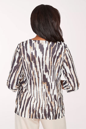 Woman wearing a patterned blouse with a plain background