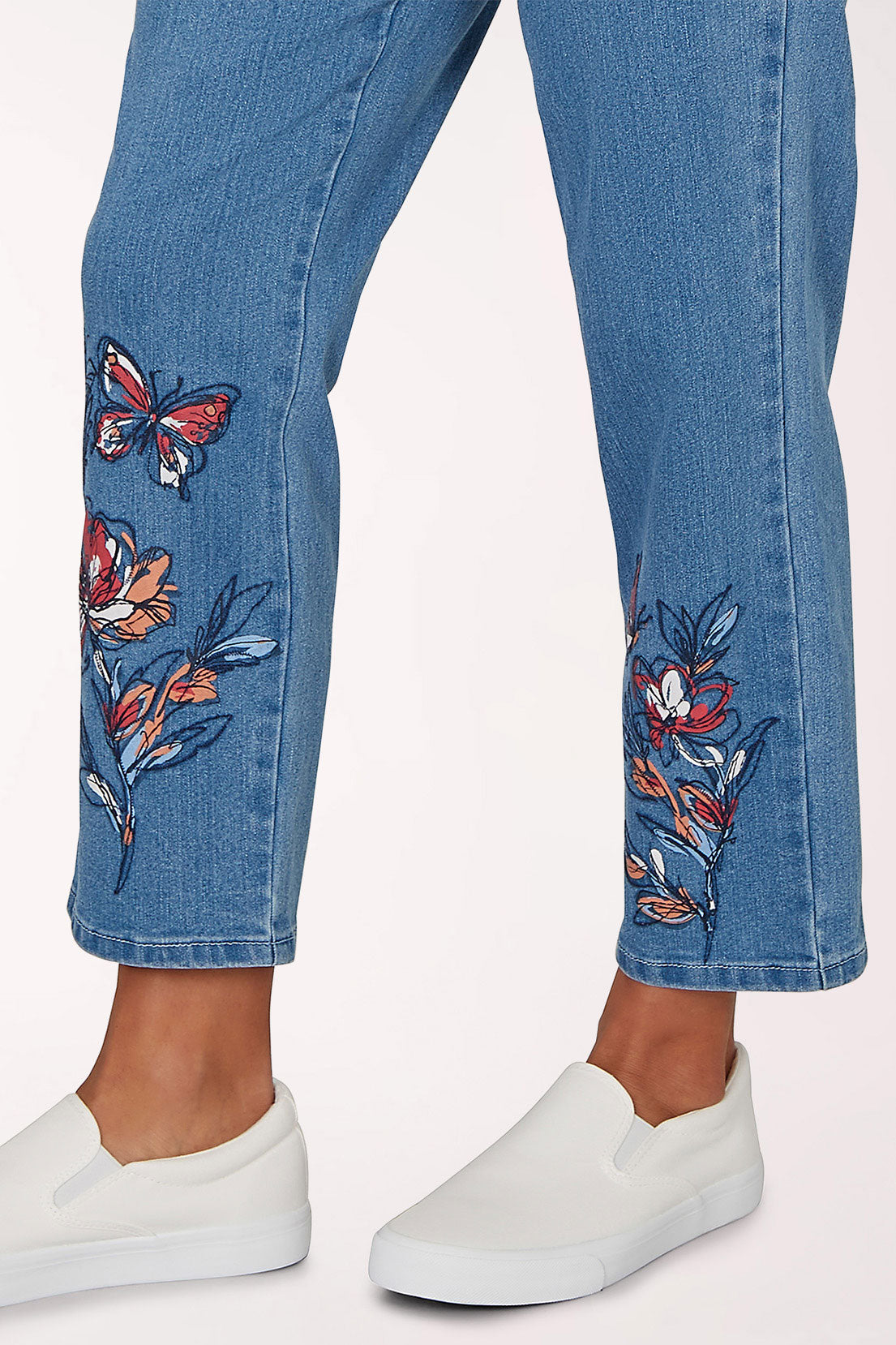 Blue jeans with butterfly embroidery on a white background