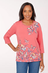 Woman wearing a pink floral blouse with blue jeans on a white background