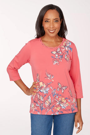 Woman wearing a pink floral blouse with blue jeans on a white background
