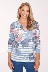 Woman wearing a floral and striped long-sleeve top on a white background