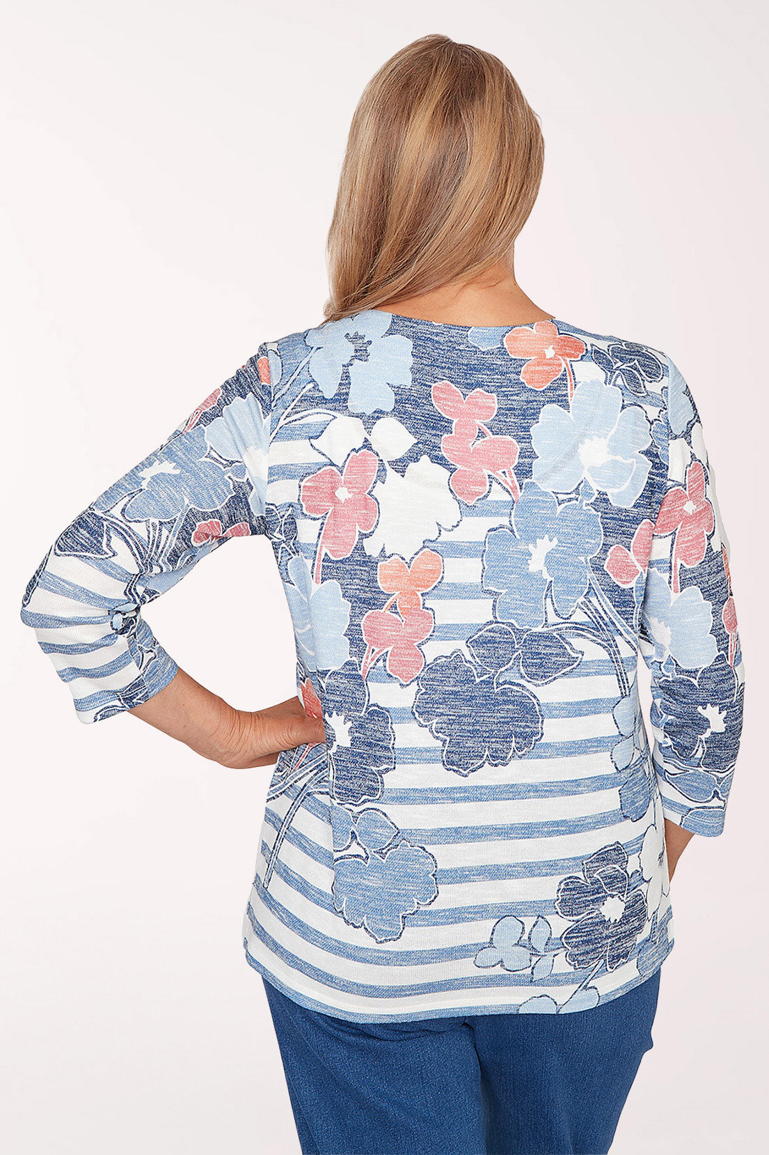 Woman wearing a floral and striped long-sleeve top on a white background