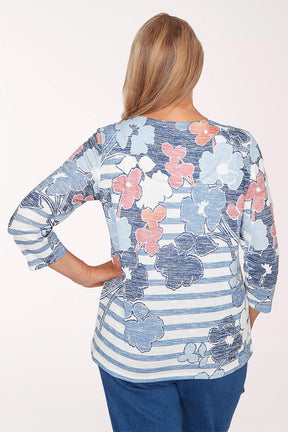 Woman wearing a floral and striped long-sleeve top on a white background