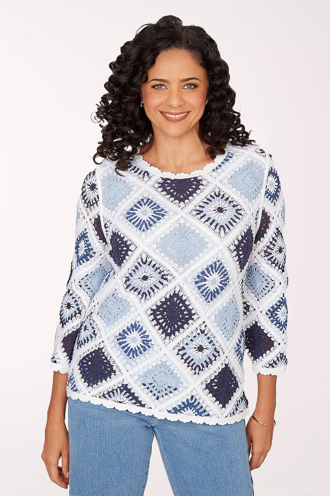 Woman wearing a blue and white patterned sweater on a white background