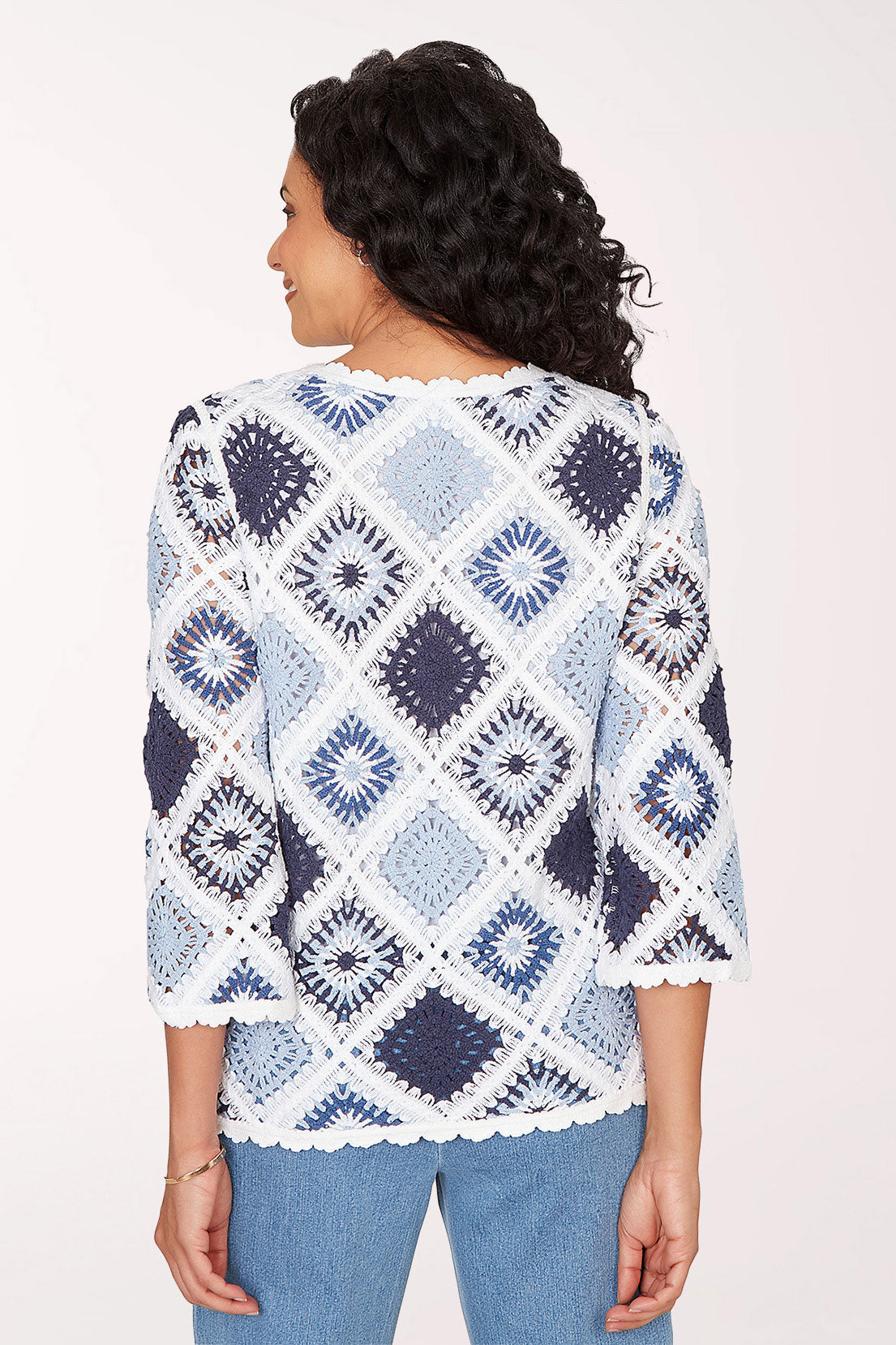 Woman wearing a blue and white patterned sweater on a white background