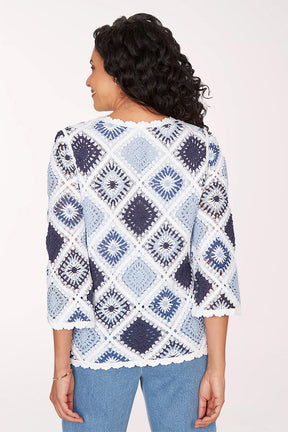 Woman wearing a blue and white patterned sweater on a white background