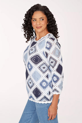 Woman wearing a blue and white patterned sweater on a white background
